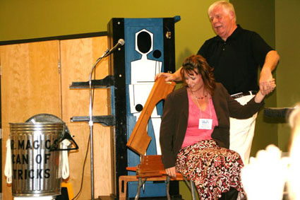 Magician Jim Stott sawing a volunteer in half